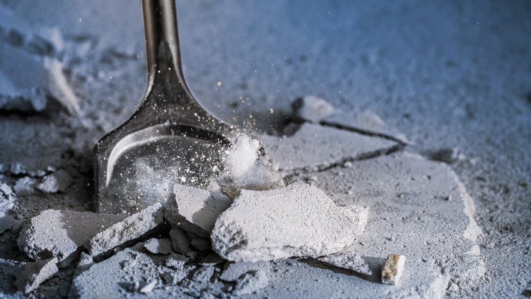 Chisel breaking concrete debris on a construction site.