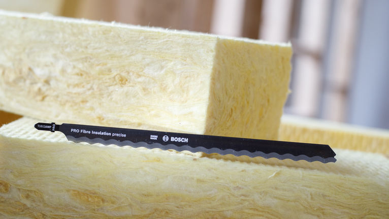 Saw blade placed on yellow insulation material.