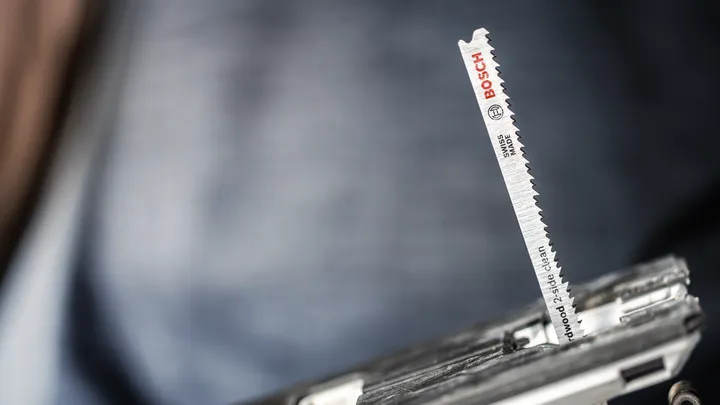 Close-up of a jigsaw blade installed in a power tool.