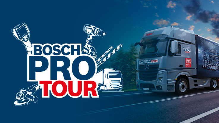 En grå Bosch ProTour-lastbil kör längs en väg med verktyg i bakgrunden.
