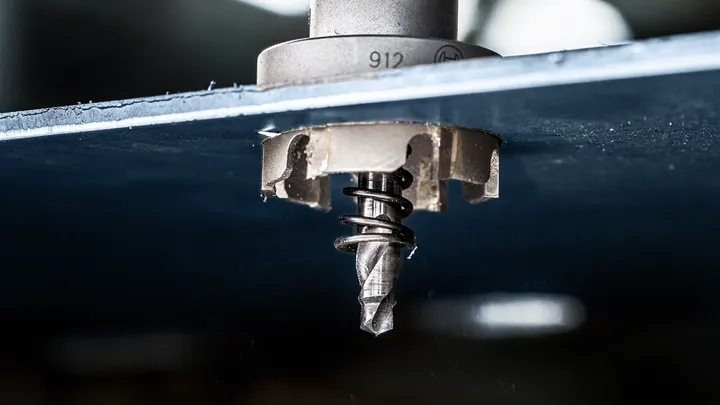 Hålsåg borrar ett cirkulärt hål genom en metallplåt.