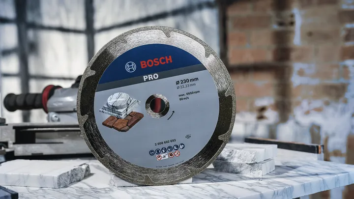 Ett diamantsågblad står upprätt på en marmorplatta i en verkstad.