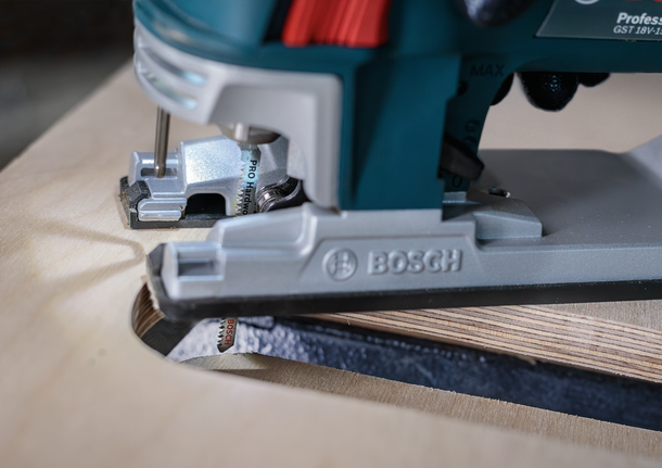 Sticksåg gör ett krökt snitt genom plywood.