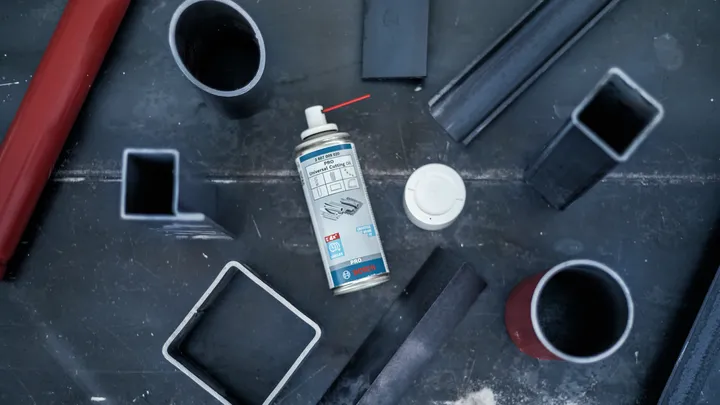 Sprayburk placerad på en metallbänk omgiven av olika stålrör.