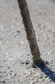 Betongvibratoraxel som blandar våt betong på en byggarbetsplats.
