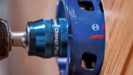 Hålsågstillsats borrar i en träplanka.