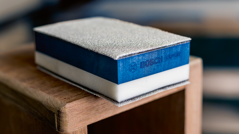 Brusilna goba počiva na vogalu lesene površine.