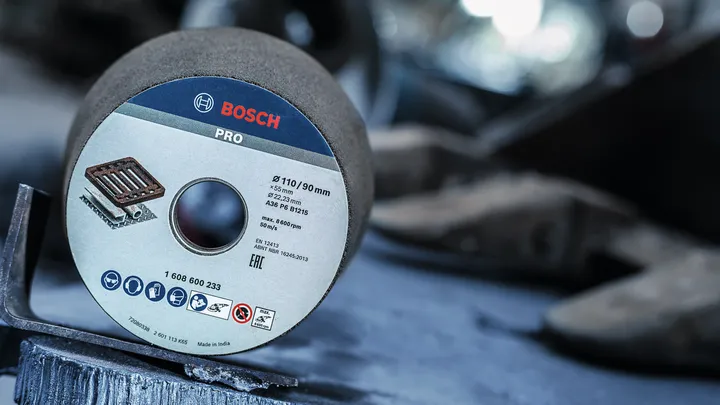 Brusilni disk leži na kovinski površini v industrijskem okolju.