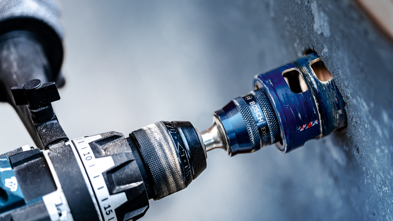 Elektrická vŕtačka s vrtákom na diery na vŕtanie do betónovej steny.