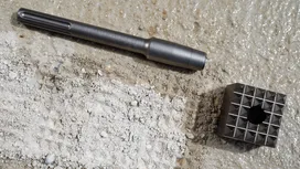 Dláto a špicatý kovový nástroj spočívajúci na drsnom betóne.