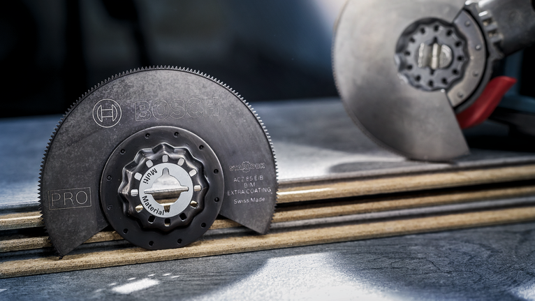 Circular power tool blade resting on stacked wooden boards in a workshop.