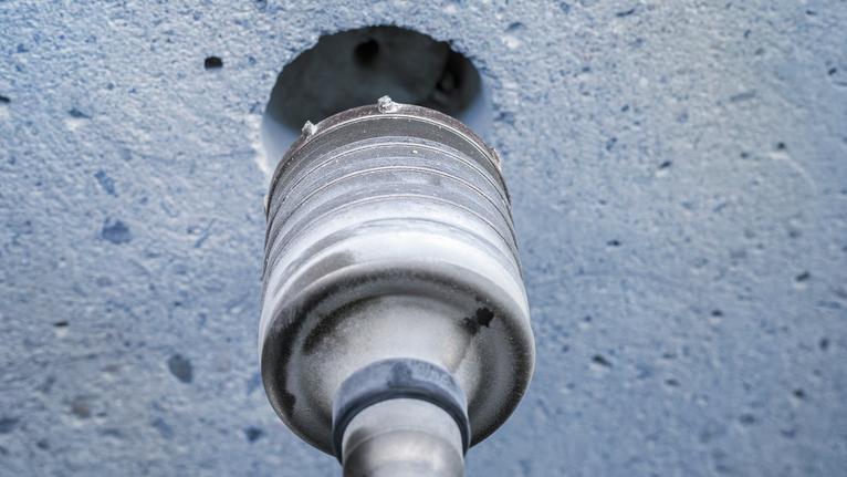 Hole saw drilling into a concrete wall.