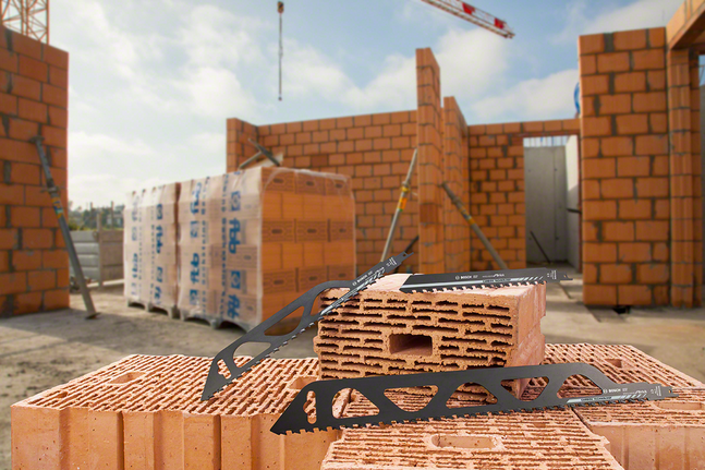 Lames de scie posées sur des briques creuses sur un chantier de construction.