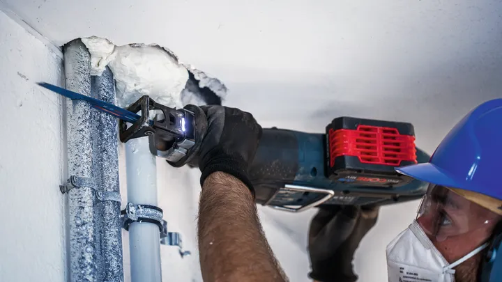 Yığılmış metal boruları kesen alternatif hareketli testere bıçağı.