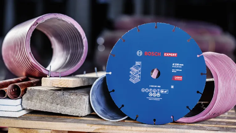 Metal ve beton karot örneklerinin yanında bir çalışma tezgahında sergilenen elmas testere bıçağı.