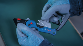 Person wearing safety equipment replaces a utility knife blade.