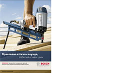 Рука тримає синій акумуляторний інструмент Bosch на дерев'яній поверхні.