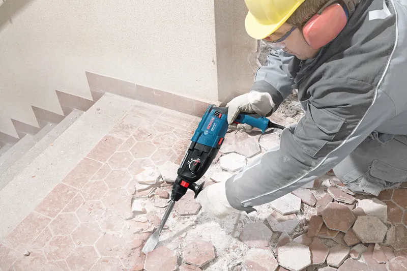 Trabajador utilizando taladro eléctrico.