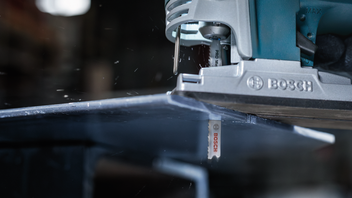 Sierra de calar cortando una chapa metálica en un taller.