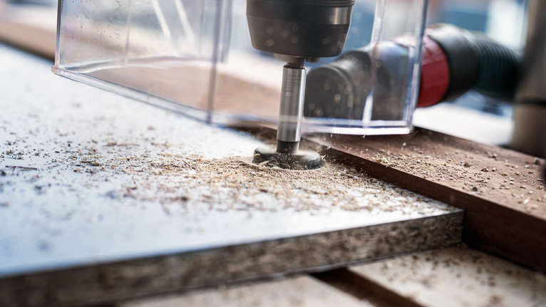 Sistema de extracción de polvo acoplado a una herramienta eléctrica que perfora madera laminada.