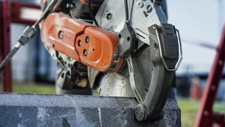 Circular saw cutting through a concrete block at a construction site.