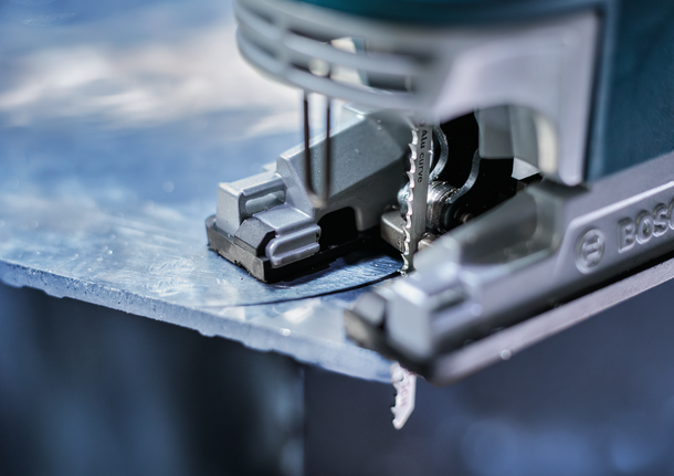 Jigsaw cutting through a sheet of metal.