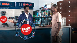 Two men interact at a Bosch Professional tools store with pricing signs visible.