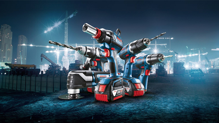 Three Bosch Professional tools in blue, set against a construction site backdrop.